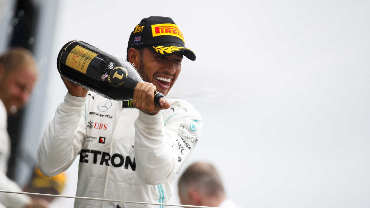 SILVERSTONE, UNITED KINGDOM - JULY 14: Lewis Hamilton, Mercedes AMG F1, 1st position, sprays Champagne on the podium during the British GP at Silverstone on July 14, 2019 in Silverstone, United Kingdom. (Photo by Joe Portlock / LAT Images)