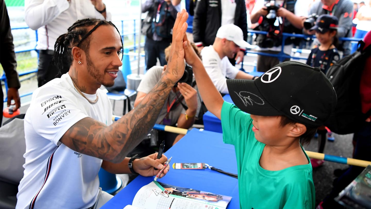 SUZUKA, JAPAN - OCTOBER 10: Lewis Hamilton of Great Britain and Mercedes GP greets fans at the