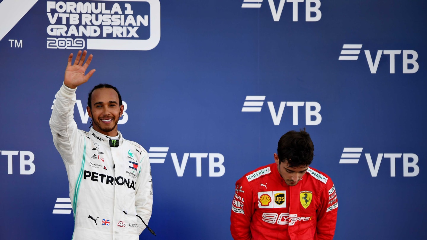 SOCHI, RUSSIA - SEPTEMBER 29: Race winner Lewis Hamilton of Great Britain and Mercedes GP celebrates as third placed Charles Leclerc of Monaco and Ferrari looks dejected on the podium during the F1 Grand Prix of Russia at Sochi Autodrom on September 29, 2019 in Sochi, Russia. (Photo by Clive Mason/Getty Images)