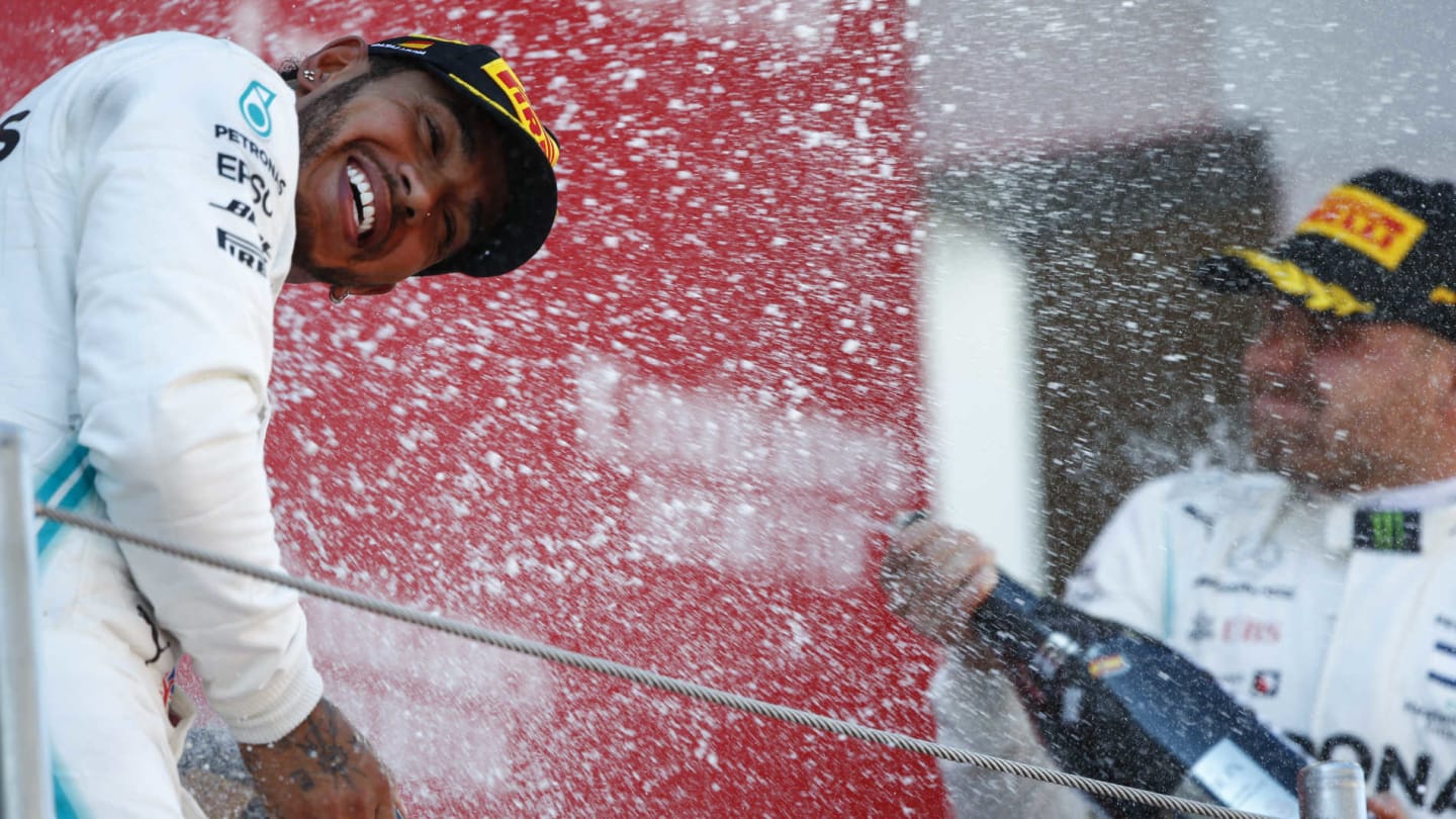 CIRCUIT DE BARCELONA-CATALUNYA, SPAIN - MAY 12: Lewis Hamilton, Mercedes AMG F1, 1st position, is blasted with Champagne by Valtteri Bottas, Mercedes AMG F1, 2nd position, on the podium during the Spanish GP at Circuit de Barcelona-Catalunya on May 12, 2019 in Circuit de Barcelona-Catalunya, Spain. (Photo by Andy Hone / LAT Images)