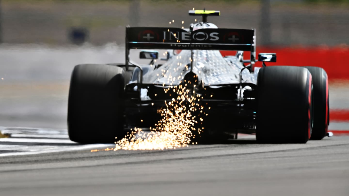 NORTHAMPTON, ENGLAND - AUGUST 08: Sparks fly behind Valtteri Bottas of Finland driving the (77) Mercedes AMG Petronas F1 Team Mercedes W11 during qualifying for the F1 70th Anniversary Grand Prix at Silverstone on August 08, 2020 in Northampton, England. (Photo by Clive Mason - Formula 1/Formula 1 via Getty Images)