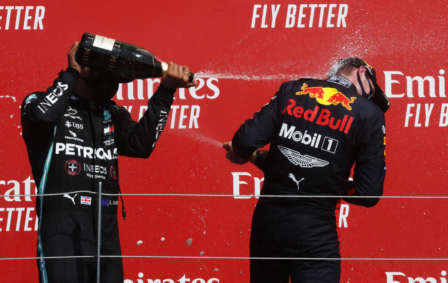 NORTHAMPTON, ENGLAND - AUGUST 09: Race winner Max Verstappen of Netherlands and Red Bull Racing and second placed Lewis Hamilton of Great Britain and Mercedes GP celebrate on the podium  during the F1 70th Anniversary Grand Prix at Silverstone on August 09, 2020 in Northampton, England. (Photo by Frank Augstein/Pool via Getty Images)