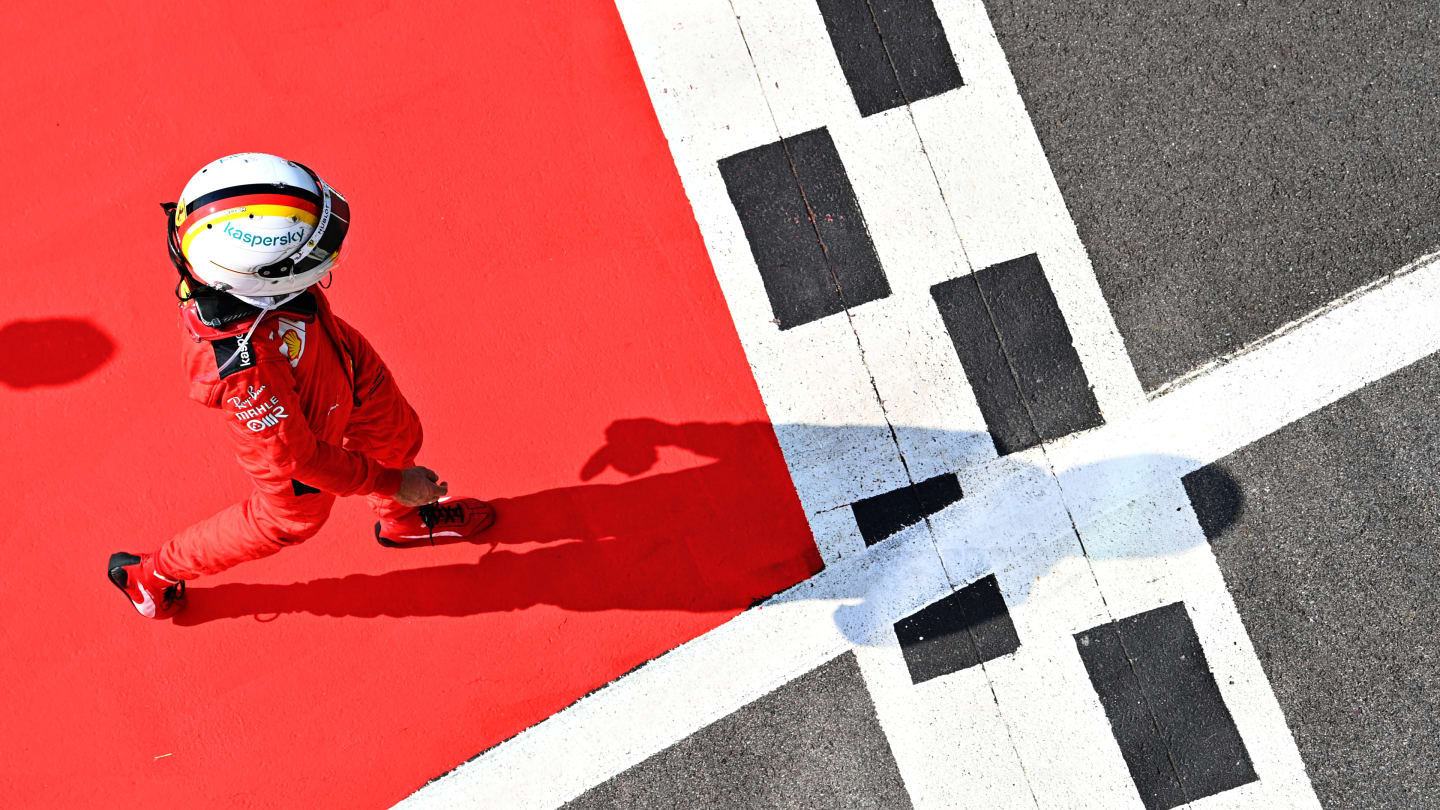NORTHAMPTON, ENGLAND - AUGUST 09: Sebastian Vettel of Germany and Ferrari walks in parc ferme