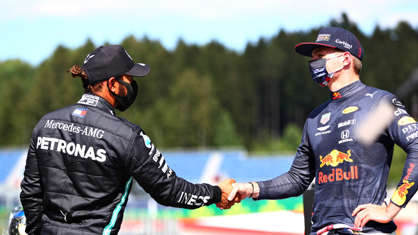 SPIELBERG, AUSTRIA - JULY 04: Second place qualifier Lewis Hamilton of Great Britain and Mercedes GP and third place qualifier Max Verstappen of Netherlands and Red Bull Racing shake hands in parc ferme during qualifying for the Formula One Grand Prix of Austria at Red Bull Ring on July 04, 2020 in Spielberg, Austria. (Photo by Dan Istitene - Formula 1/Formula 1 via Getty Images)