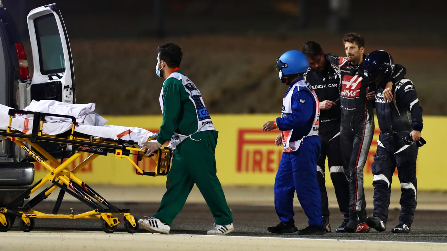 BAHRAIN, BAHRAIN - NOVEMBER 29: Romain Grosjean of France and Haas F1 is pictured being helped into