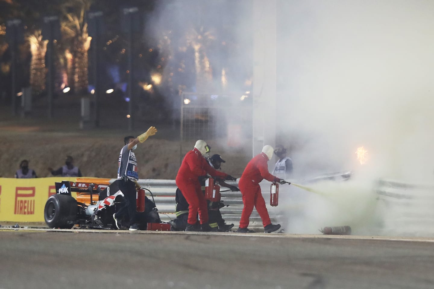BAHRAIN, BAHRAIN - NOVEMBER 29: Track marshals put out a fire of the crash of Romain Grosjean of