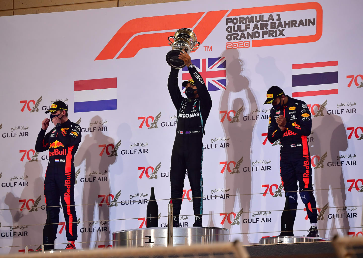 BAHRAIN, BAHRAIN - NOVEMBER 29: Race winner Lewis Hamilton of Great Britain and Mercedes GP, second placed Max Verstappen of Netherlands and Red Bull Racing and third placed Alexander Albon of Thailand and Red Bull Racing celebrate on the podium during the F1 Grand Prix of Bahrain at Bahrain International Circuit on November 29, 2020 in Bahrain, Bahrain. (Photo by Giuseppe Cacace - Pool/Getty Images)