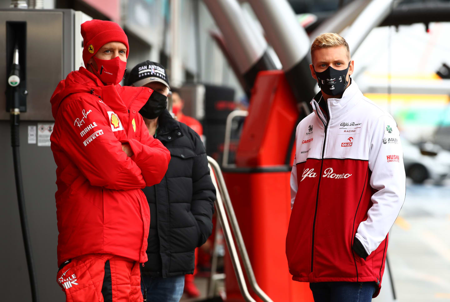 NUERBURG, GERMANY - OCTOBER 09: Sebastian Vettel of Germany and Ferrari and Mick Schumacher of Germany and Alfa Romeo Racing talk in the Pitlane during a weather delayed FP2 during practice ahead of the F1 Eifel Grand Prix at Nuerburgring on October 09, 2020 in Nuerburg, Germany. (Photo by Mark Thompson/Getty Images)