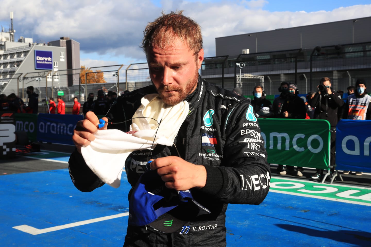NUERBURG, GERMANY - OCTOBER 10: Pole position qualifier Valtteri Bottas of Finland and Mercedes GP removes his balaclava in parc ferme during qualifying ahead of the F1 Eifel Grand Prix at Nuerburgring on October 10, 2020 in Nuerburg, Germany. (Photo by Wolfgang Rattay - Pool/Getty Images)