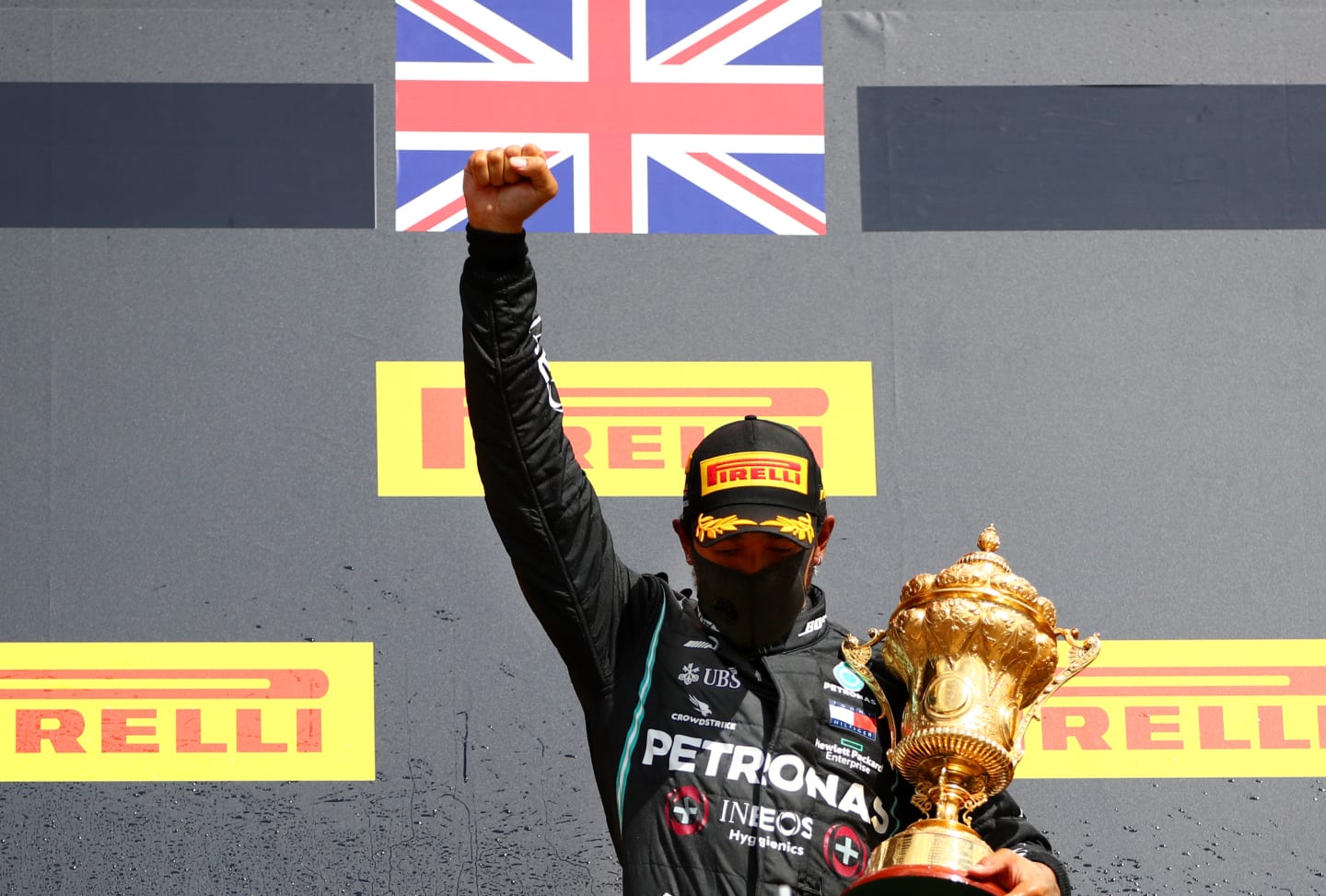 NORTHAMPTON, ENGLAND - AUGUST 02: Lewis Hamilton of Great Britain and Mercedes GP raises his fist as he celebrates on the podium after winning the Formula One Grand Prix of Hungary at Silverstone on August 02, 2020 in Northampton, England. (Photo by Dan Istitene - Formula 1/Formula 1 via Getty Images)