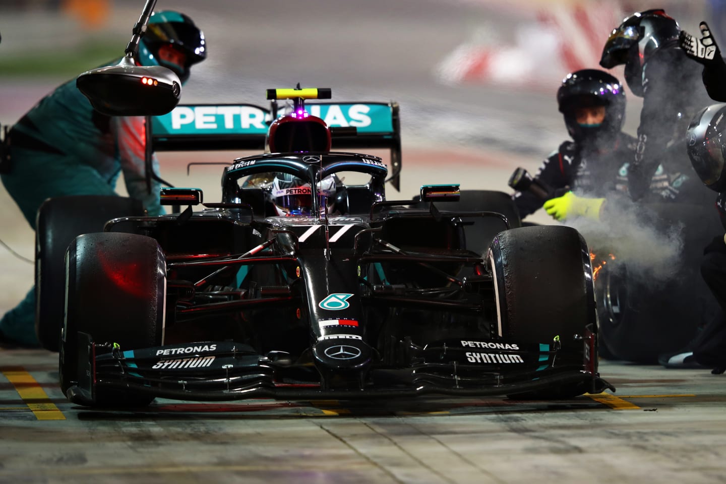 BAHRAIN, BAHRAIN - DECEMBER 06: Valtteri Bottas of Finland driving the (77) Mercedes AMG Petronas F1 Team Mercedes W11 makes a pitstop as smoke pour from his front left brake during the F1 Grand Prix of Sakhir at Bahrain International Circuit on December 06, 2020 in Bahrain, Bahrain. (Photo by Mark Thompson/Getty Images)
