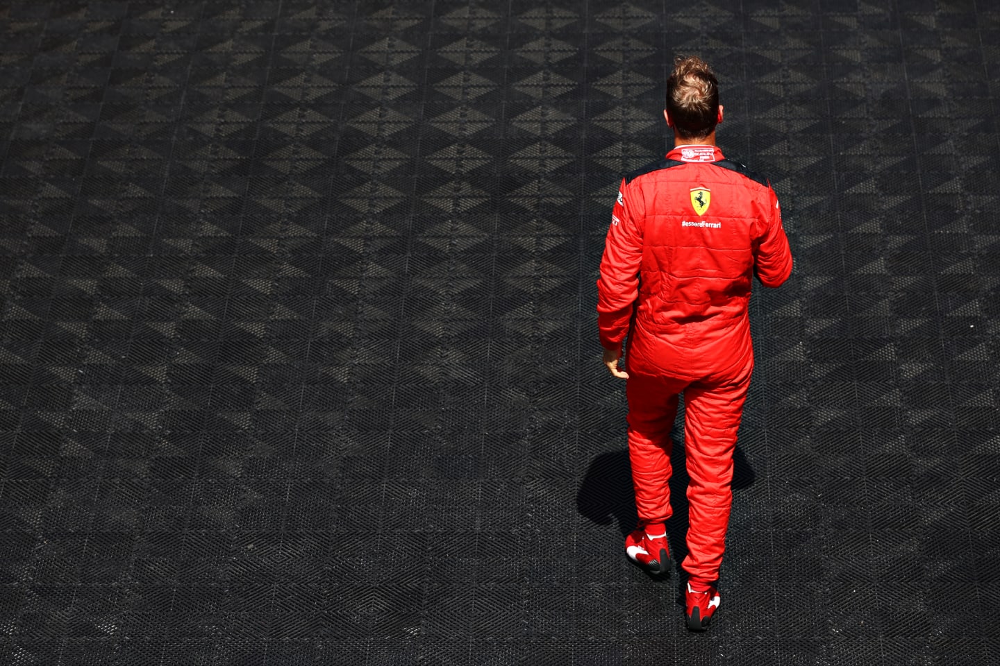 BARCELONA, SPAIN - AUGUST 16: Sebastian Vettel of Germany and Ferrari walks to the grid before the