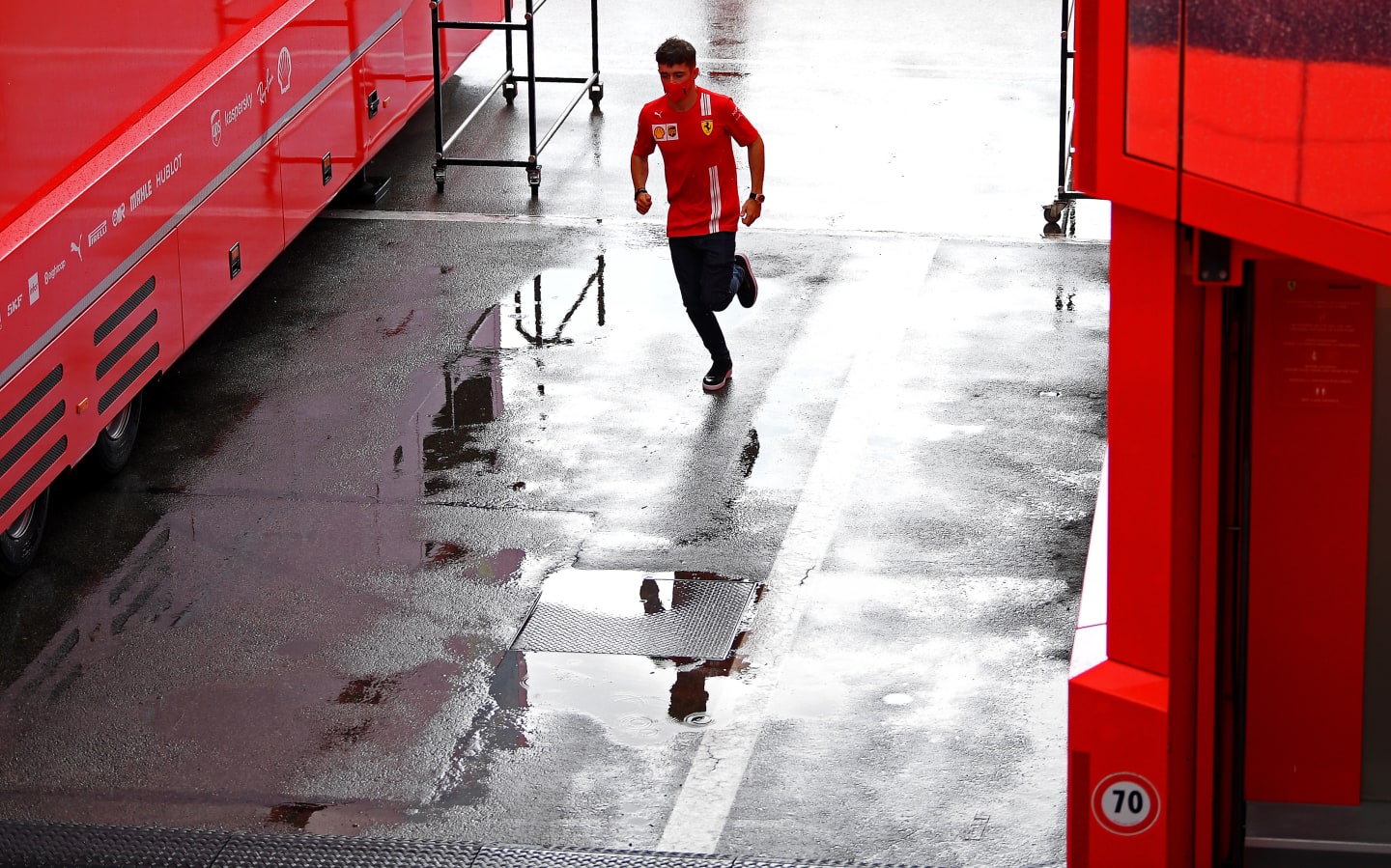 BARCELONA, SPAIN - AUGUST 13: Charles Leclerc of Monaco and Ferrari runs through the paddock during