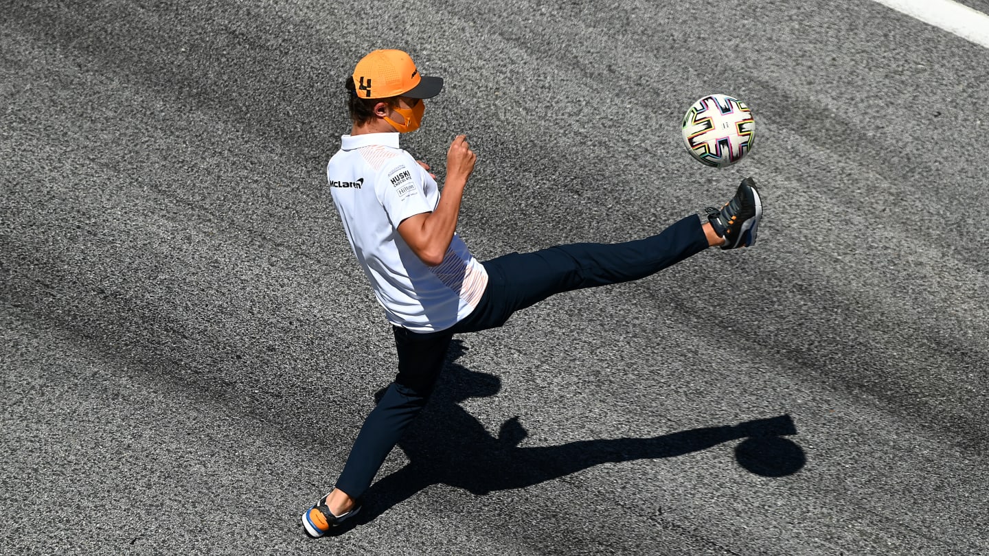 SPIELBERG, AUSTRIA - JULY 09: Lando Norris of Great Britain and McLaren F1 plays football on the