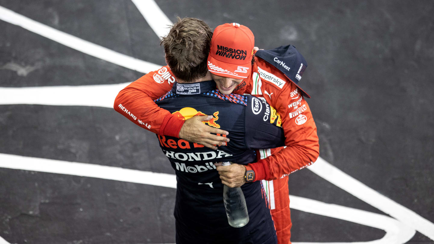 ABU DHABI, UNITED ARAB EMIRATES - DECEMBER 12: Race winner and 2021 F1 World Drivers Champion Max Verstappen of Netherlands and Red Bull Racing is congratulated by Carlos Sainz of Spain and Ferrari in parc ferme during the F1 Grand Prix of Abu Dhabi at Yas Marina Circuit on December 12, 2021 in Abu Dhabi, United Arab Emirates. (Photo by Mahmoud Khaled - Formula 1/Formula 1 via Getty Images)