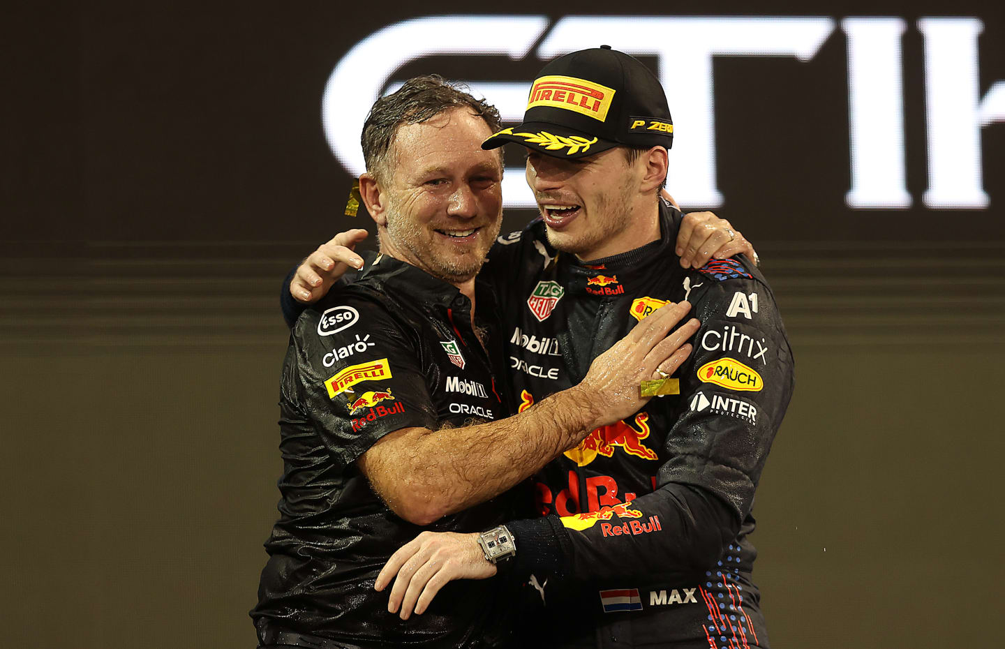 ABU DHABI, UNITED ARAB EMIRATES - DECEMBER 12: Race winner and 2021 F1 World Drivers Champion Max Verstappen of Netherlands and Red Bull Racing celebrates with Red Bull Racing Team Principal Christian Horner on the podium during the F1 Grand Prix of Abu Dhabi at Yas Marina Circuit on December 12, 2021 in Abu Dhabi, United Arab Emirates. (Photo by Lars Baron/Getty Images)