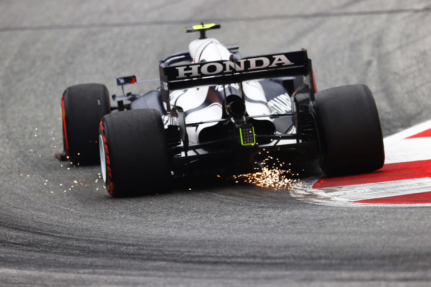 SPIELBERG, AUSTRIA - JULY 02: Sparks fly behind Pierre Gasly of France driving the (10) Scuderia AlphaTauri AT02 Honda during practice ahead of the F1 Grand Prix of Austria at Red Bull Ring on July 02, 2021 in Spielberg, Austria. (Photo by Clive Rose/Getty Images)