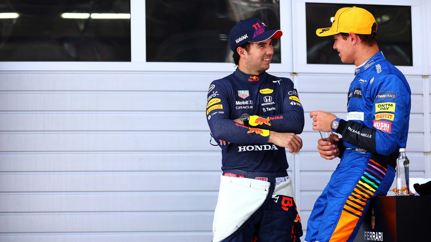 SPIELBERG, AUSTRIA - JULY 03: Second place qualifier Lando Norris of Great Britain and McLaren F1 and third place qualifier Sergio Perez of Mexico and Red Bull Racing talk in parc ferme during qualifying ahead of the F1 Grand Prix of Austria at Red Bull Ring on July 03, 2021 in Spielberg, Austria. (Photo by Dan Istitene - Formula 1/Formula 1 via Getty Images)