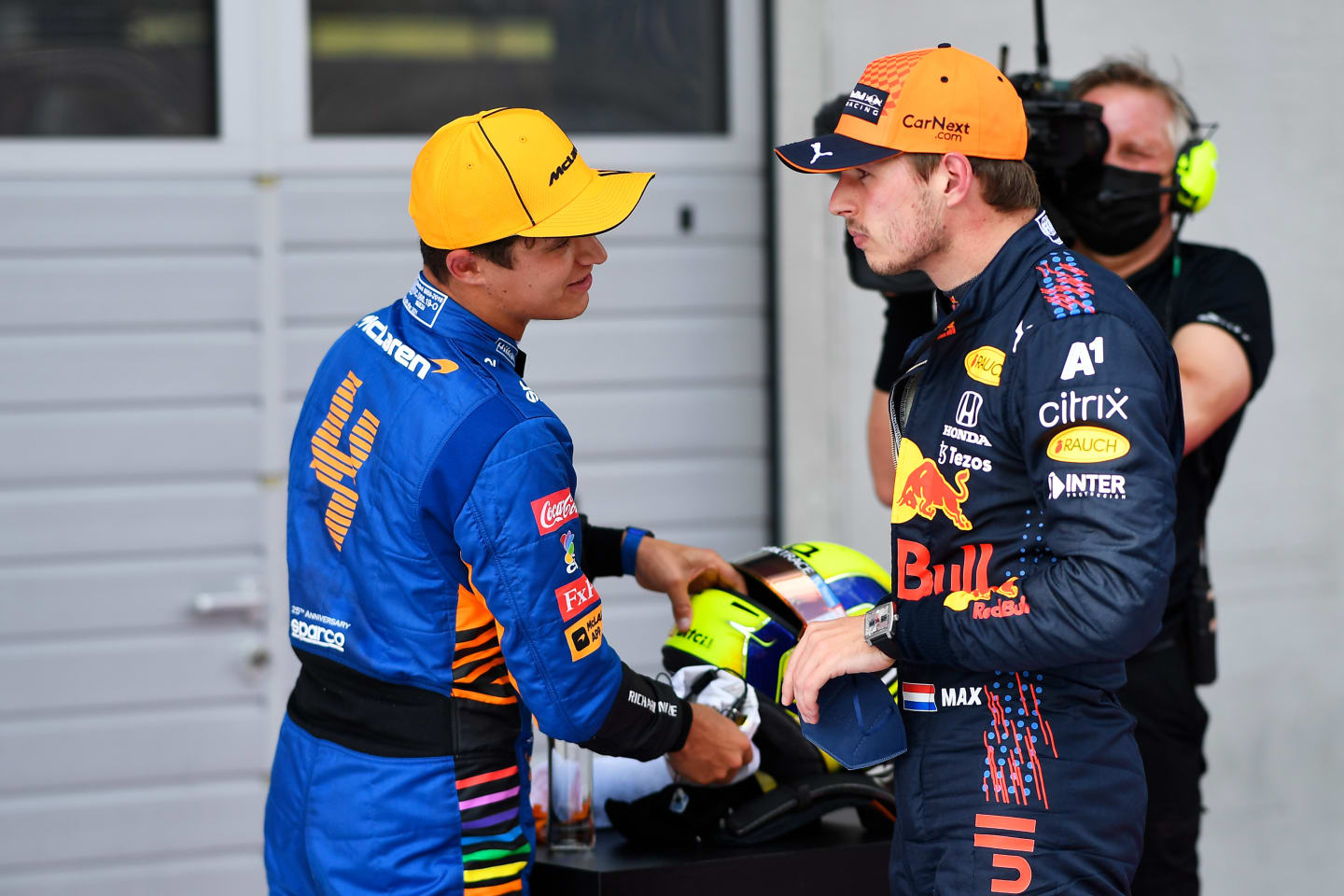 SPIELBERG, AUSTRIA - JULY 03: Pole position qualifier Max Verstappen of Netherlands and Red Bull Racing and second place qualifier Lando Norris of Great Britain and McLaren F1 talk in parc ferme during qualifying ahead of the F1 Grand Prix of Austria at Red Bull Ring on July 03, 2021 in Spielberg, Austria. (Photo by Christian Bruna - Pool/Getty Images)