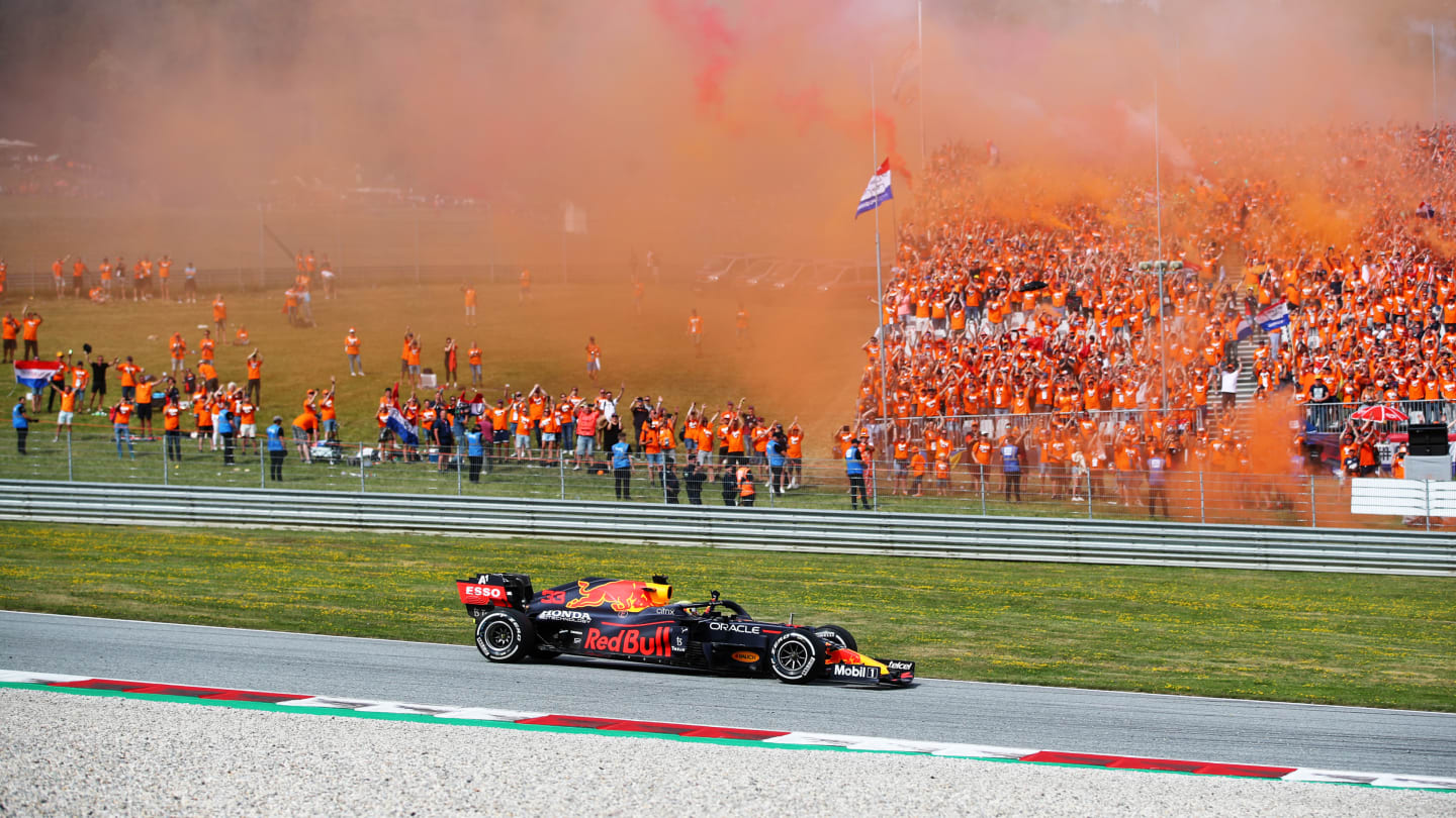 SPIELBERG, AUSTRIA - JULY 04: Race winner Max Verstappen of the Netherlands driving the (33) Red Bull Racing RB16B Honda past a grandstand full of his fans celebrating during the F1 Grand Prix of Austria at Red Bull Ring on July 04, 2021 in Spielberg, Austria. (Photo by Joe Portlock - Formula 1/Formula 1 via Getty Images)