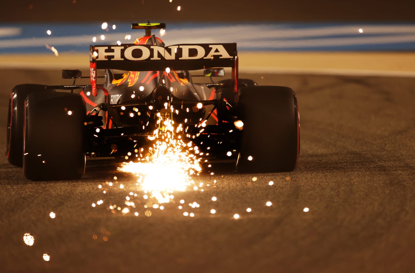 BAHRAIN, BAHRAIN - MARCH 26: Sparks fly behind Sergio Perez of Mexico driving the (11) Red Bull