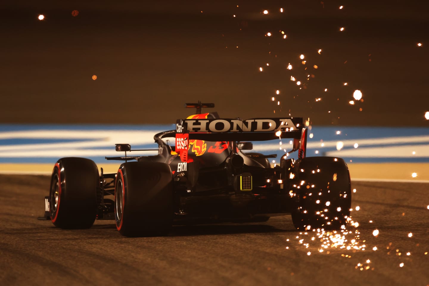 BAHRAIN, BAHRAIN - MARCH 26: Sparks fly behind Max Verstappen of the Netherlands driving the (33) Red Bull Racing RB16B Honda on track during practice ahead of the F1 Grand Prix of Bahrain at Bahrain International Circuit on March 26, 2021 in Bahrain, Bahrain. (Photo by Lars Baron/Getty Images)