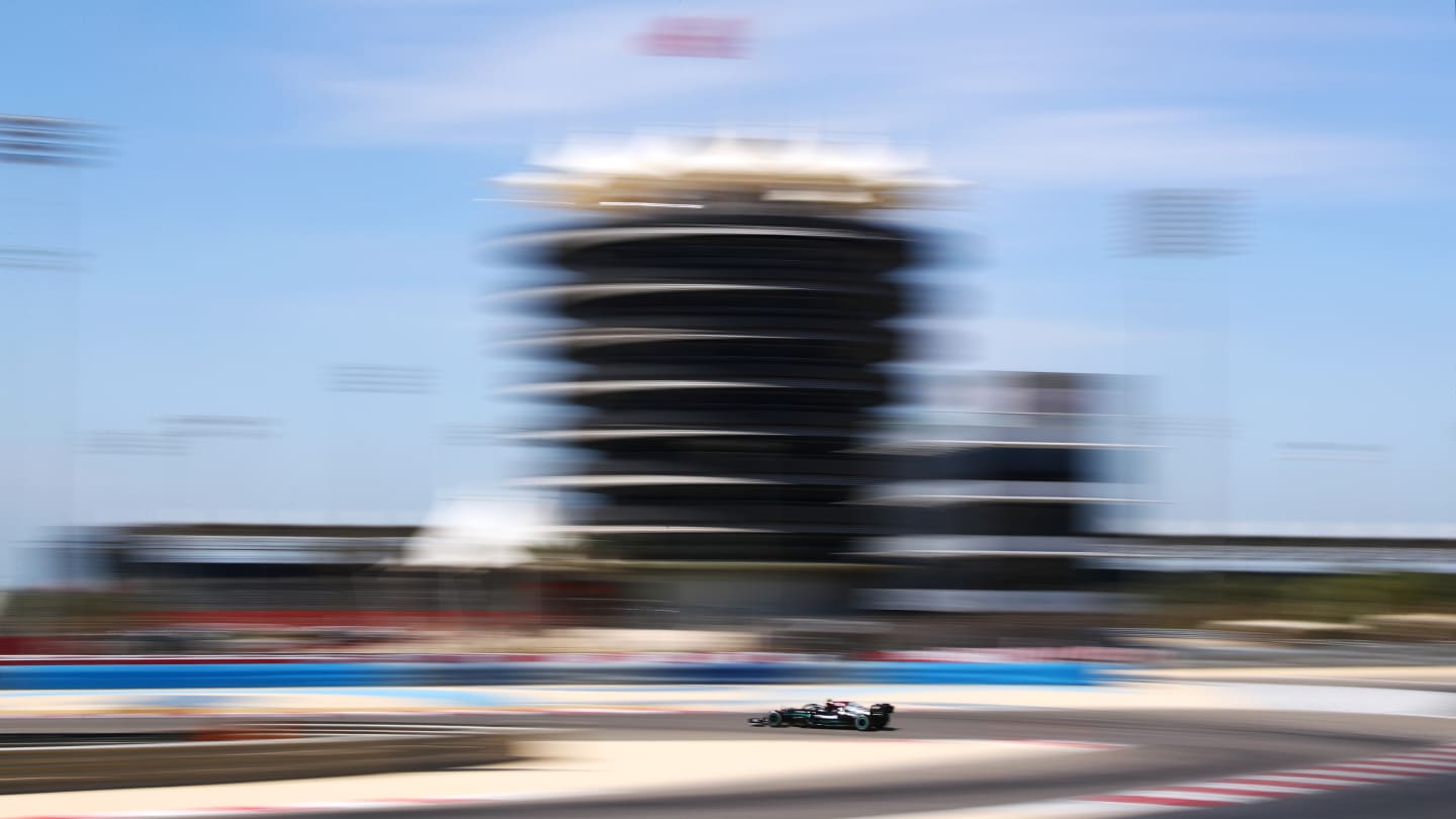 Bottas's Mercedes a blur amongst the Bahrain circuit buildings