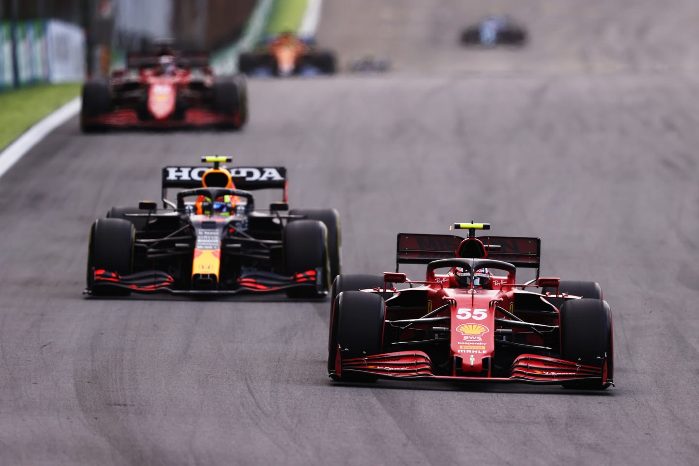 SAO PAULO, BRAZIL - NOVEMBER 13: Carlos Sainz of Spain driving the (55) Scuderia Ferrari SF21 leads Sergio Perez of Mexico driving the (11) Red Bull Racing RB16B Honda during the sprint ahead of the F1 Grand Prix of Brazil at Autodromo Jose Carlos Pace on November 13, 2021 in Sao Paulo, Brazil. (Photo by Lars Baron/Getty Images)