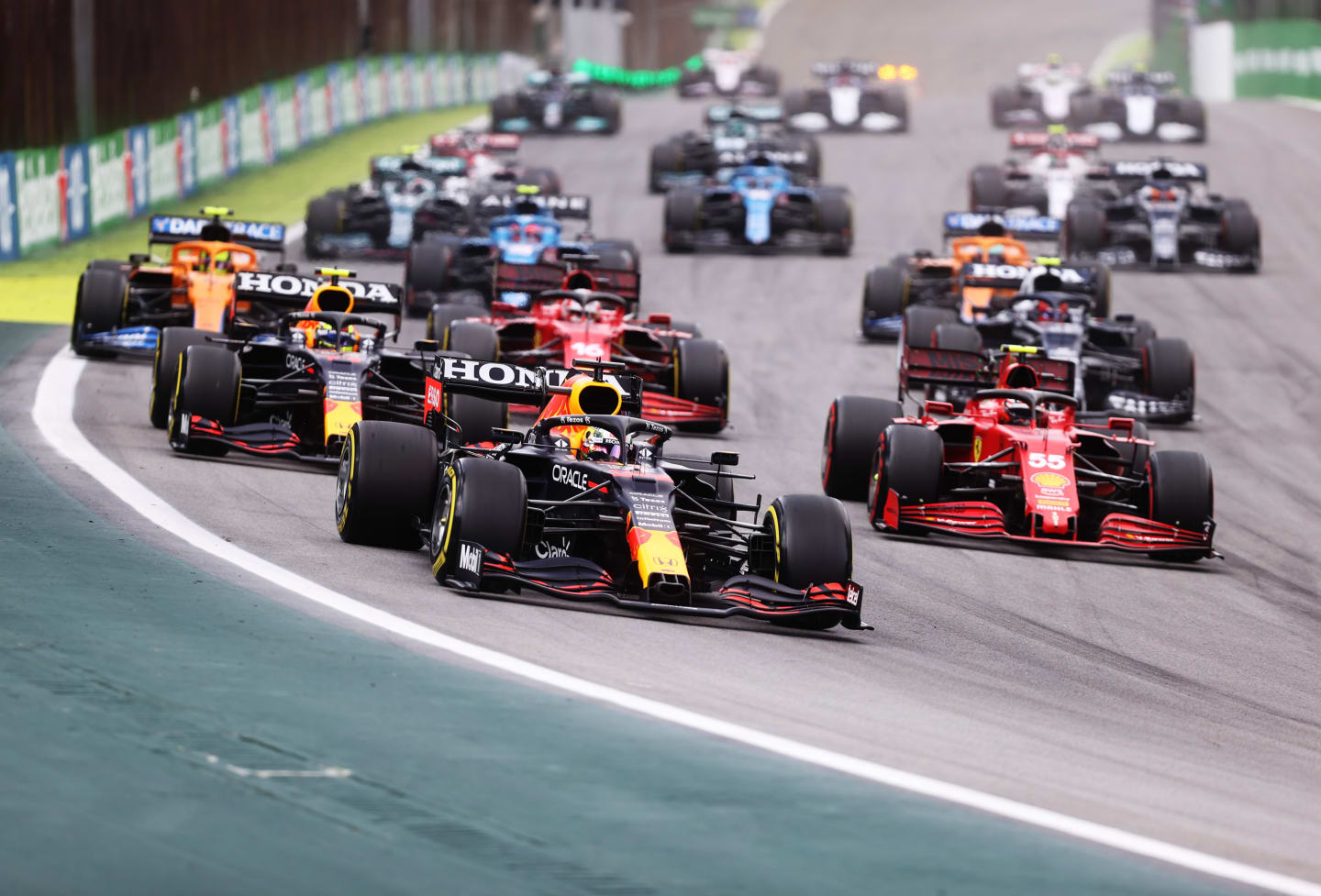 SAO PAULO, BRAZIL - NOVEMBER 13: Max Verstappen of the Netherlands driving the (33) Red Bull Racing RB16B Honda leads Sergio Perez of Mexico driving the (11) Red Bull Racing RB16B Honda and Carlos Sainz of Spain driving the (55) Scuderia Ferrari SF21 and during the sprint ahead of the F1 Grand Prix of Brazil at Autodromo Jose Carlos Pace on November 13, 2021 in Sao Paulo, Brazil. (Photo by Lars Baron/Getty Images)