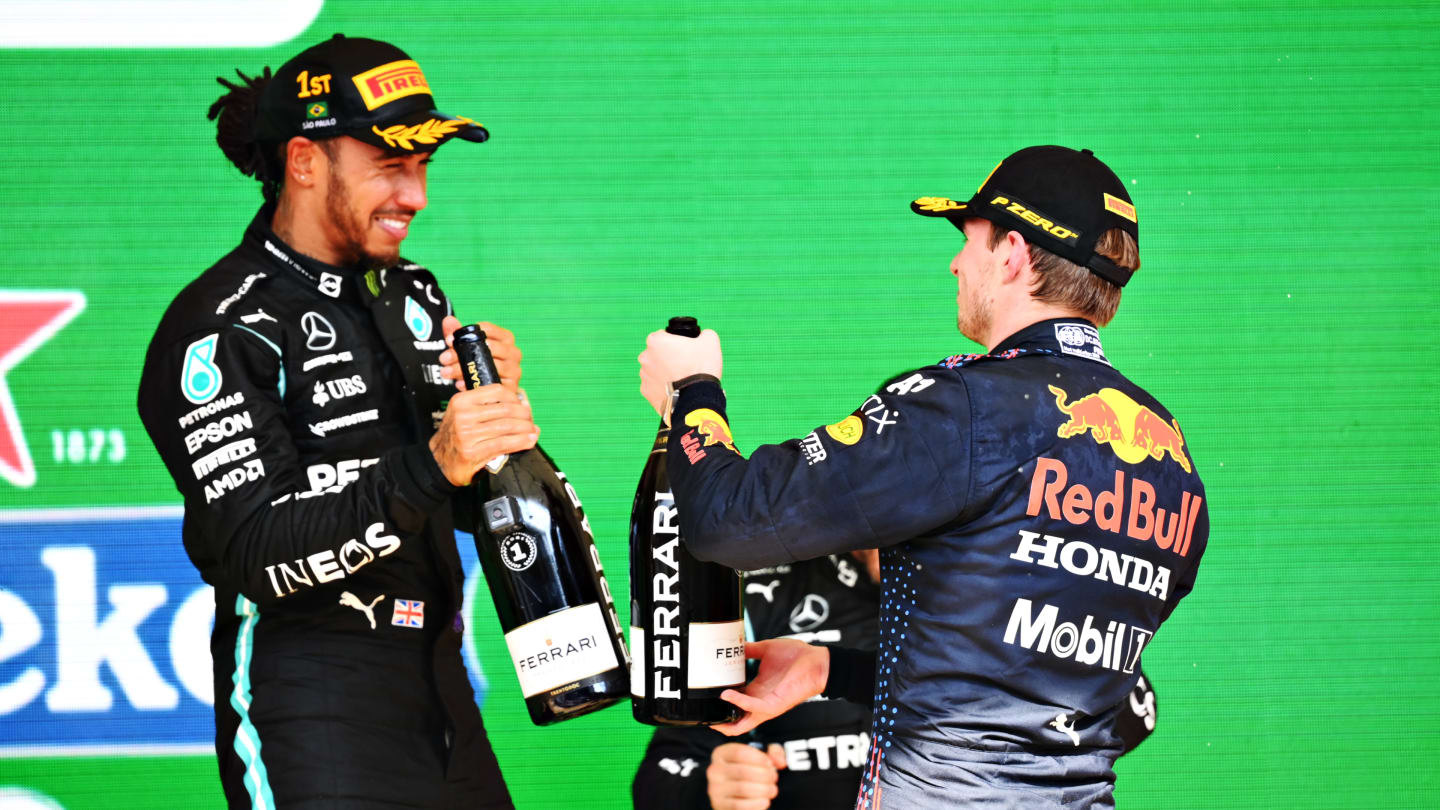SAO PAULO, BRAZIL - NOVEMBER 14: Race winner Lewis Hamilton of Great Britain and Mercedes GP and second placed Max Verstappen of Netherlands and Red Bull Racing celebrate on the podium during the F1 Grand Prix of Brazil at Autodromo Jose Carlos Pace on November 14, 2021 in Sao Paulo, Brazil. (Photo by Clive Mason - Formula 1/Formula 1 via Getty Images)