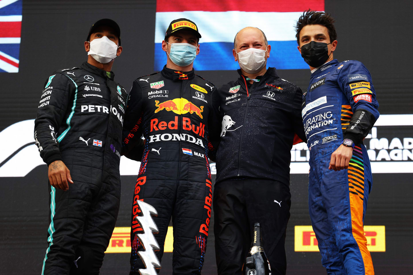 IMOLA, ITALY - APRIL 18: Second placed Lewis Hamilton of Great Britain and Mercedes GP, race winner Max Verstappen of Netherlands and Red Bull Racing, Alastair Rew, Financial Director of Red Bull Racing and third placed Lando Norris of Great Britain and McLaren F1 celebrate on the podium after the F1 Grand Prix of Emilia Romagna at Autodromo Enzo e Dino Ferrari on April 18, 2021 in Imola, Italy. (Photo by Bryn Lennon/Getty Images)