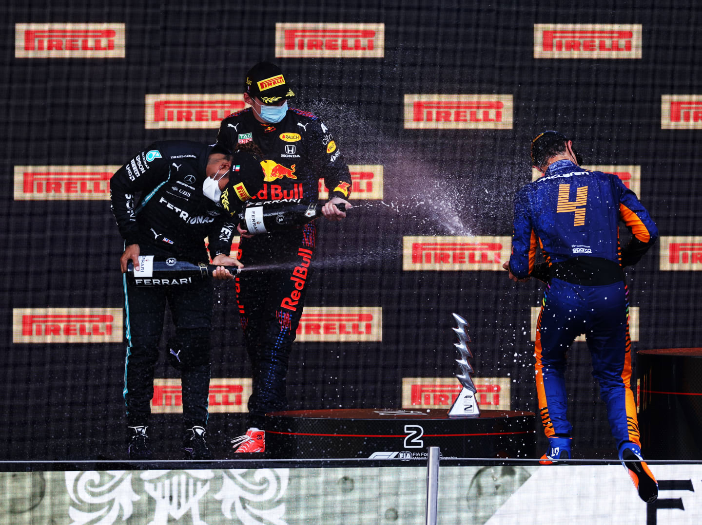 IMOLA, ITALY - APRIL 18: Second placed Lewis Hamilton of Great Britain and Mercedes GP, race winner Max Verstappen of Netherlands and Red Bull Racing and third placed Lando Norris of Great Britain and McLaren F1 celebrate with sparkling wine on the podium during the F1 Grand Prix of Emilia Romagna at Autodromo Enzo e Dino Ferrari on April 18, 2021 in Imola, Italy. (Photo by Lars Baron/Getty Images)