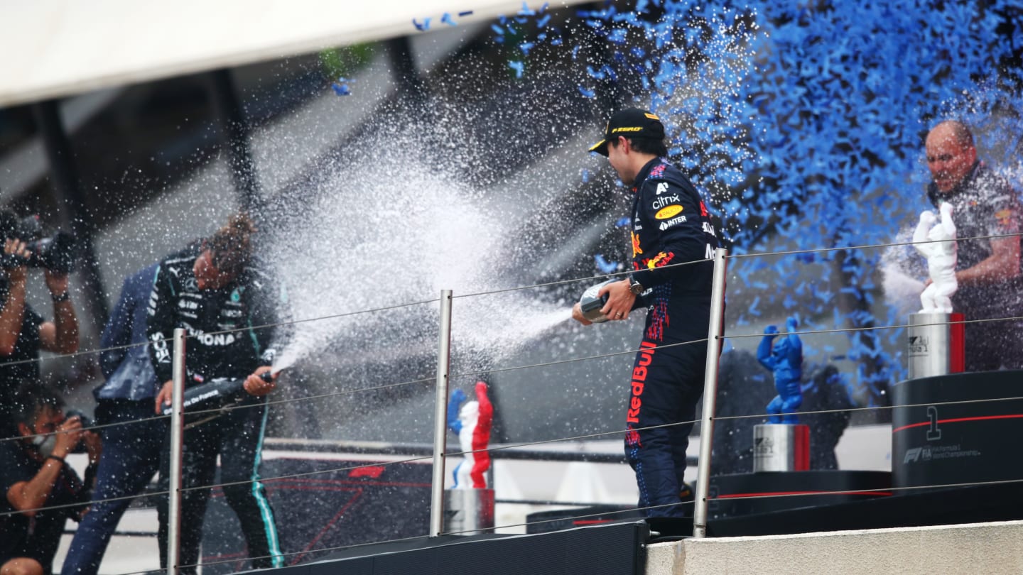 LE CASTELLET, FRANCE - JUNE 20: Third placed Sergio Perez of Mexico and Red Bull Racing and second placed Lewis Hamilton of Great Britain and Mercedes GP celebrate with sparkling wine on the podium during the F1 Grand Prix of France at Circuit Paul Ricard on June 20, 2021 in Le Castellet, France. (Photo by Joe Portlock - Formula 1/Formula 1 via Getty Images)