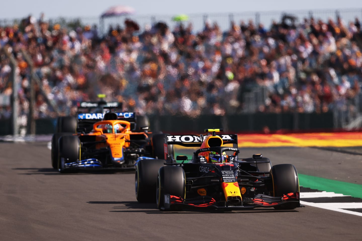 NORTHAMPTON, ENGLAND - JULY 17: Sergio Perez of Mexico driving the (11) Red Bull Racing RB16B Honda leads Daniel Ricciardo of Australia driving the (3) McLaren F1 Team MCL35M Mercedes during the Sprint for the F1 Grand Prix of Great Britain at Silverstone on July 17, 2021 in Northampton, England. (Photo by Lars Baron/Getty Images)