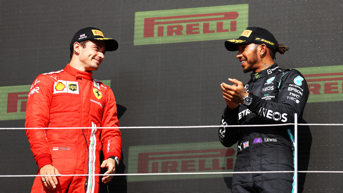 NORTHAMPTON, ENGLAND - JULY 18: Race winner Lewis Hamilton of Great Britain and Mercedes GP and second placed Charles Leclerc of Monaco and Ferrari celebrate on the podium during the F1 Grand Prix of Great Britain at Silverstone on July 18, 2021 in Northampton, England. (Photo by Bryn Lennon - Formula 1/Formula 1 via Getty Images)