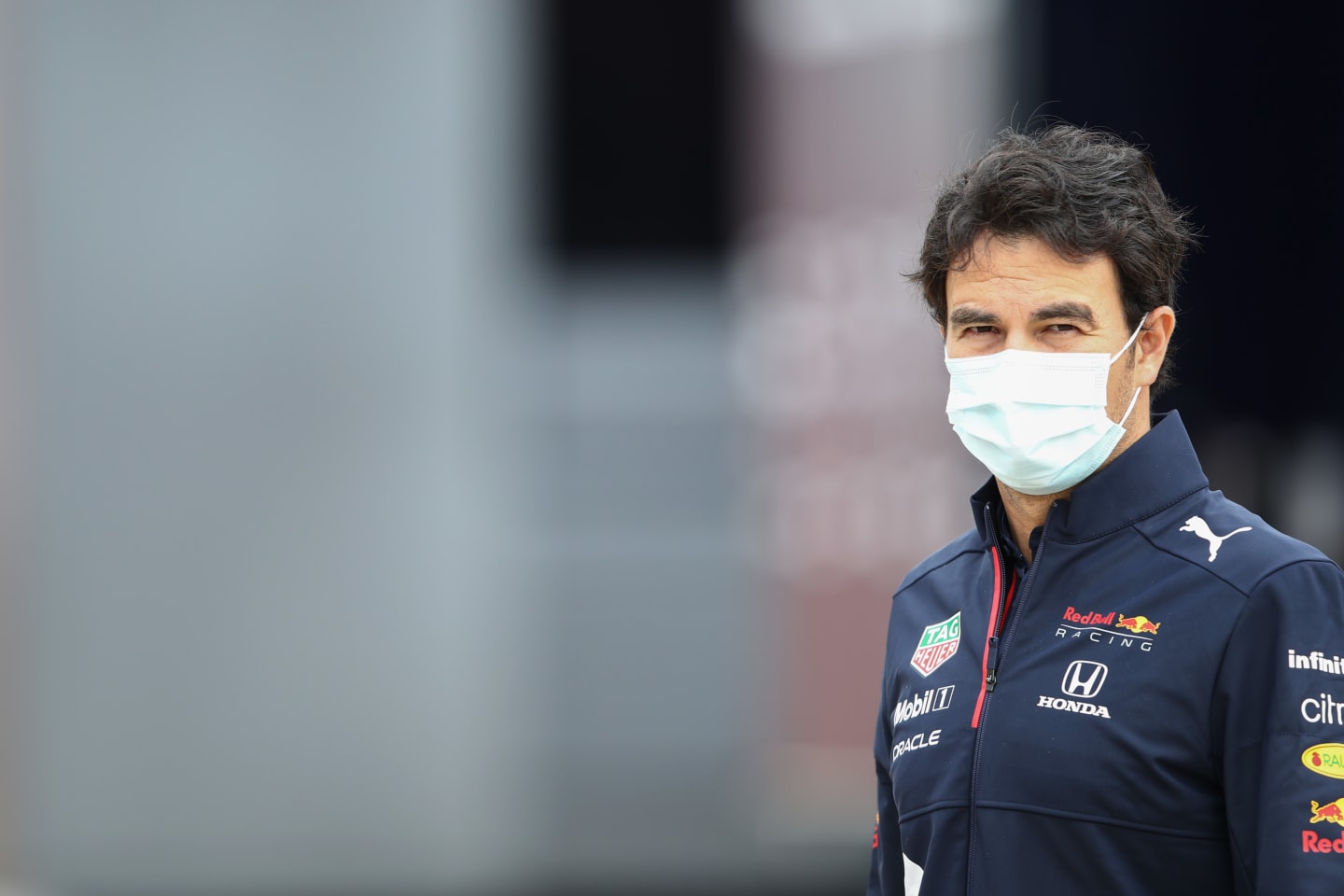 NORTHAMPTON, ENGLAND - JULY 15: Sergio Perez of Mexico and Red Bull Racing looks on in the Paddock