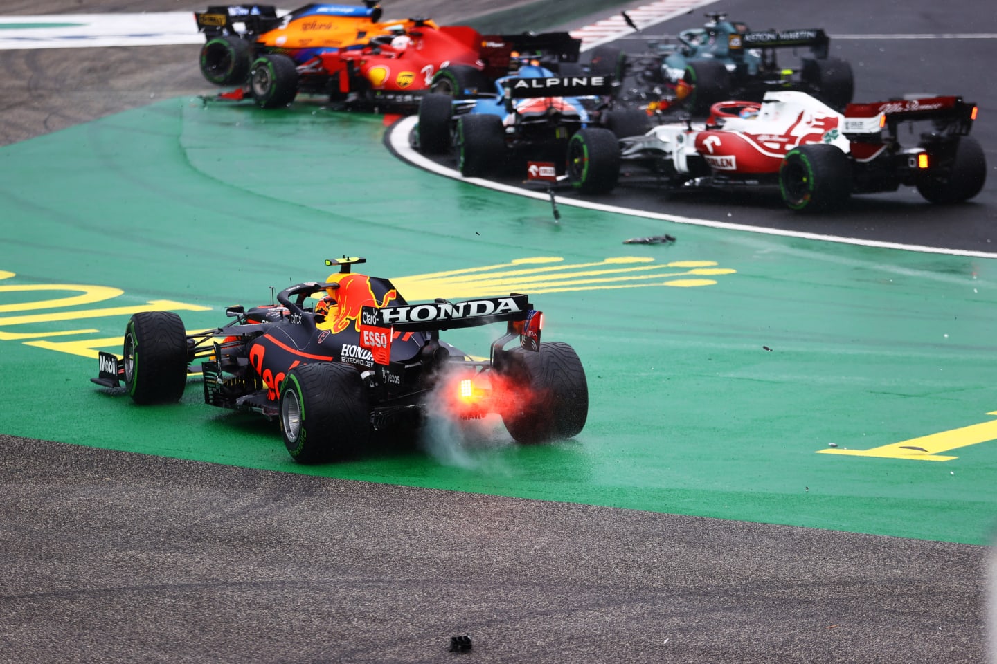 BUDAPEST, HUNGARY - AUGUST 01: Sergio Perez of Mexico driving the (11) Red Bull Racing RB16B Honda runs wide at the start as cars tangle ahead of him during the F1 Grand Prix of Hungary at Hungaroring on August 01, 2021 in Budapest, Hungary. (Photo by Bryn Lennon/Getty Images)