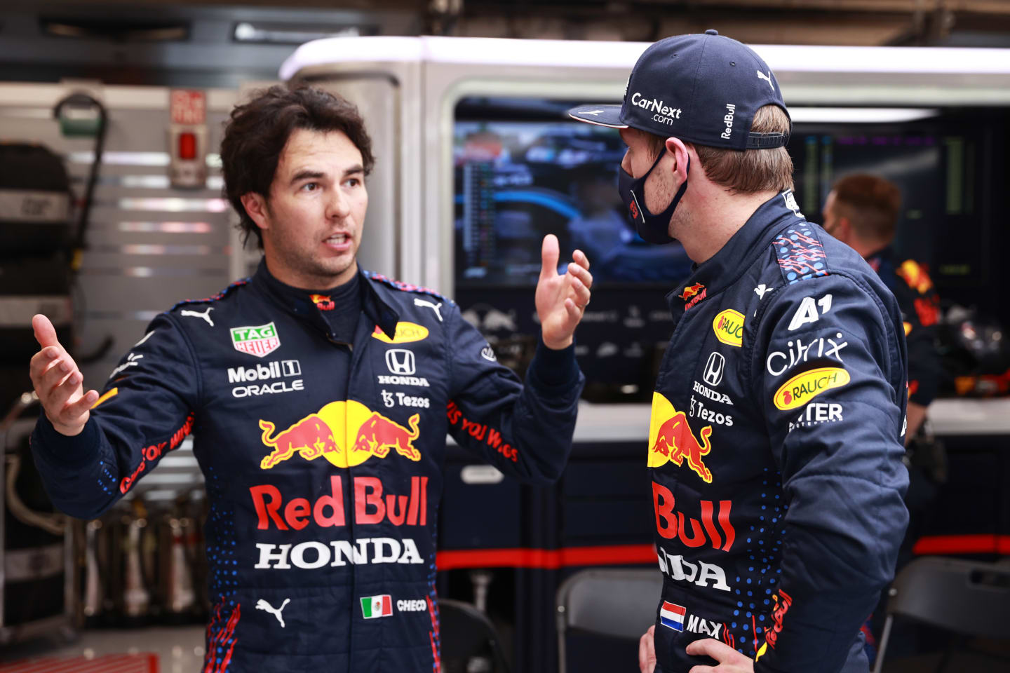 BUDAPEST, HUNGARY - AUGUST 01: Max Verstappen of Netherlands and Red Bull Racing and Sergio Perez of Mexico and Red Bull Racing talk in the garage during the red flag delay during the F1 Grand Prix of Hungary at Hungaroring on August 01, 2021 in Budapest, Hungary. (Photo by Mark Thompson/Getty Images)