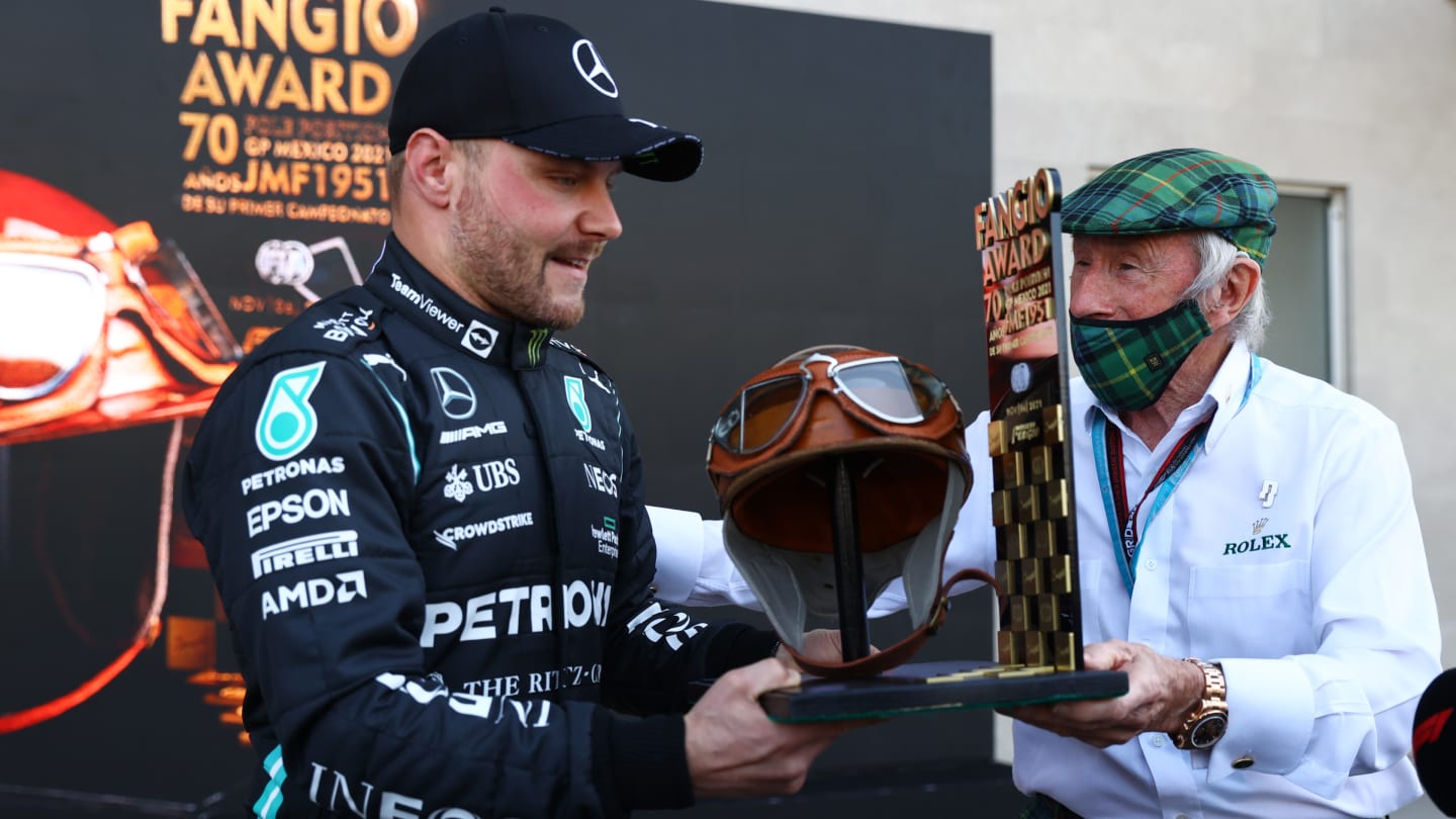 MEXICO CITY, MEXICO - NOVEMBER 06: Pole position qualifier Valtteri Bottas of Finland and Mercedes GP is presented with the Fangio Award to commemorate 70 years since Juan Manuel Fangio's first F1 World Drivers Championship win, by Sir Jackie Stewart in parc ferme during qualifying ahead of the F1 Grand Prix of Mexico at Autodromo Hermanos Rodriguez on November 06, 2021 in Mexico City, Mexico. (Photo by Bryn Lennon - Formula 1/Formula 1 via Getty Images)