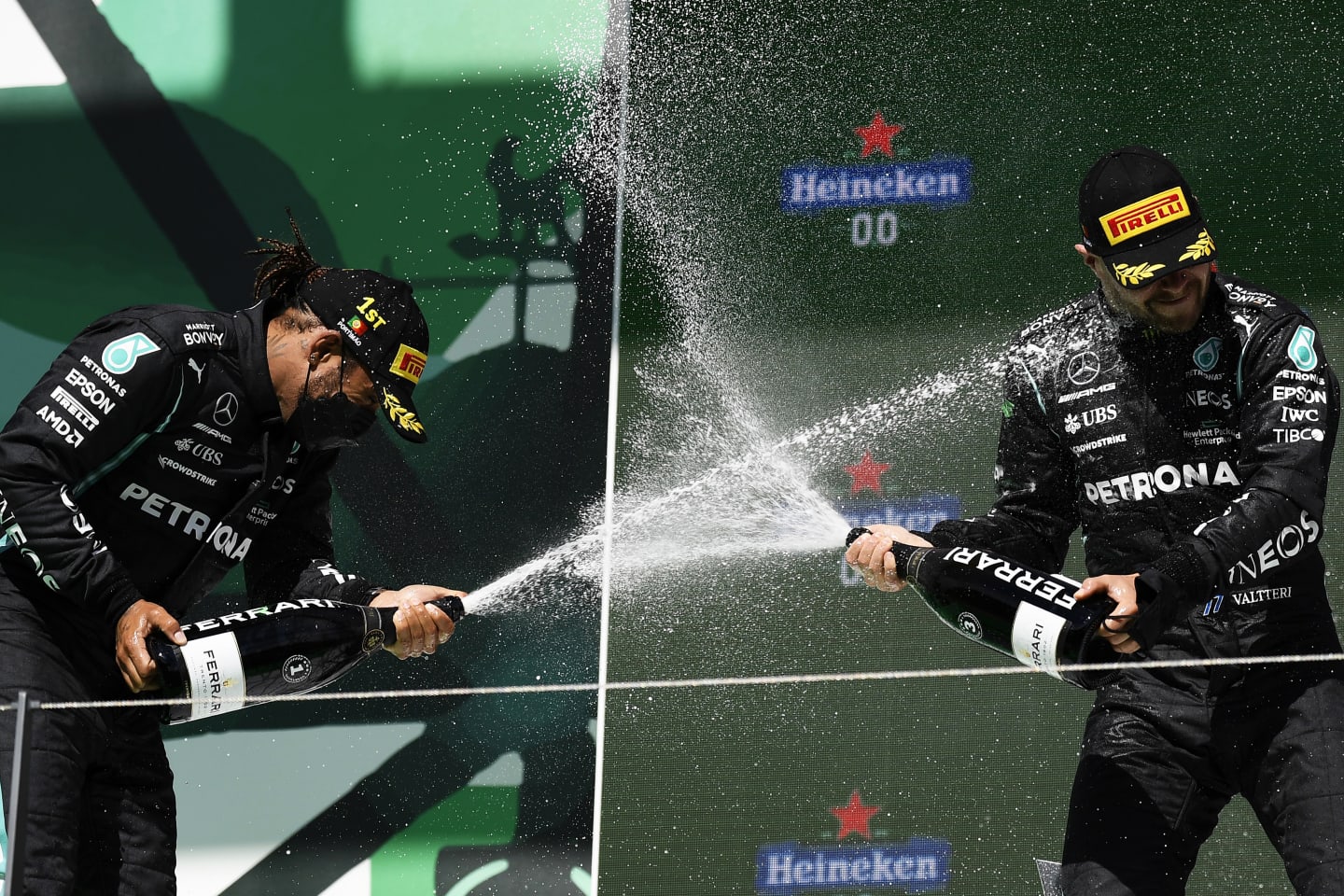 PORTIMAO, PORTUGAL - MAY 02: Race winner Lewis Hamilton of Great Britain and Mercedes GP and third placed Valtteri Bottas of Finland and Mercedes GP celebrate with sparkling wine on the podium after the F1 Grand Prix of Portugal at Autodromo Internacional Do Algarve on May 02, 2021 in Portimao, Portugal. (Photo by Gabriel Bouys - Pool/Getty Images)