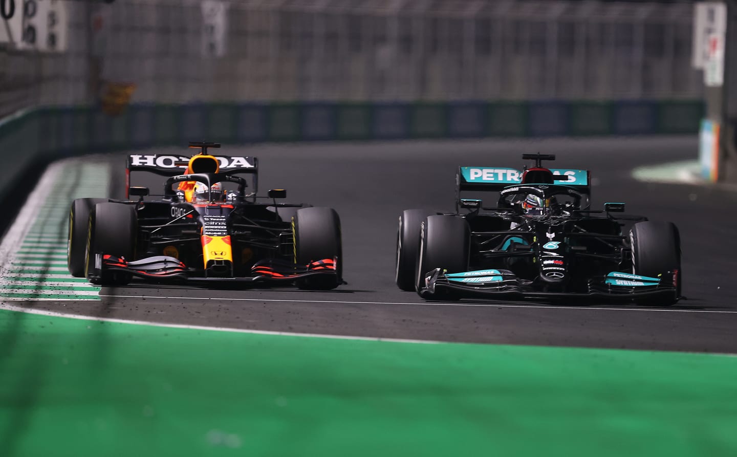 JEDDAH, SAUDI ARABIA - DECEMBER 05: Max Verstappen of the Netherlands driving the (33) Red Bull Racing RB16B Honda and Lewis Hamilton of Great Britain driving the (44) Mercedes AMG Petronas F1 Team Mercedes W12 during the F1 Grand Prix of Saudi Arabia at Jeddah Corniche Circuit on December 05, 2021 in Jeddah, Saudi Arabia. (Photo by Lars Baron/Getty Images)