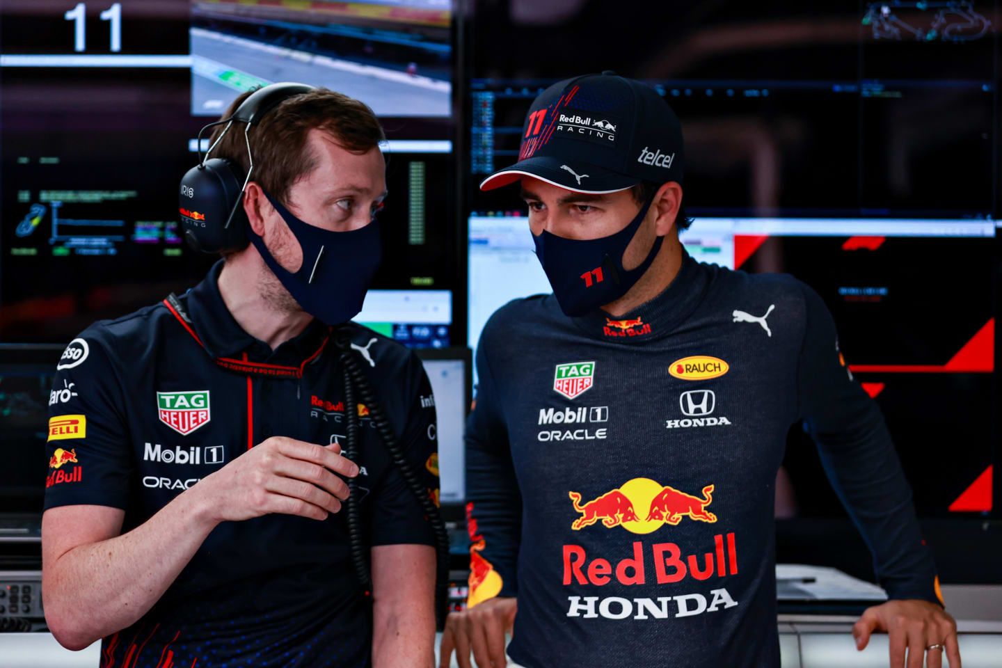 BARCELONA, SPAIN - MAY 08: Sergio Perez of Mexico and Red Bull Racing talks with an engineer in the garage during qualifying for the F1 Grand Prix of Spain at Circuit de Barcelona-Catalunya on May 08, 2021 in Barcelona, Spain. (Photo by Mark Thompson/Getty Images)