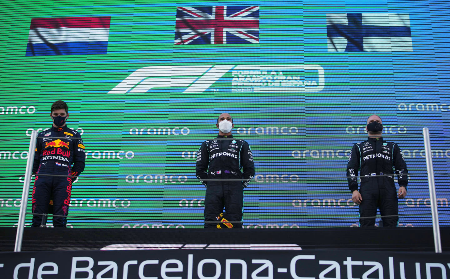 BARCELONA, SPAIN - MAY 09: Second placed Max Verstappen of Netherlands and Red Bull Racing, race winner Lewis Hamilton of Great Britain and Mercedes GP and third placed Valtteri Bottas of Finland and Mercedes GP stand on the podium during the F1 Grand Prix of Spain at Circuit de Barcelona-Catalunya on May 09, 2021 in Barcelona, Spain. (Photo by Emilio Morenatti - Pool/Getty Images)