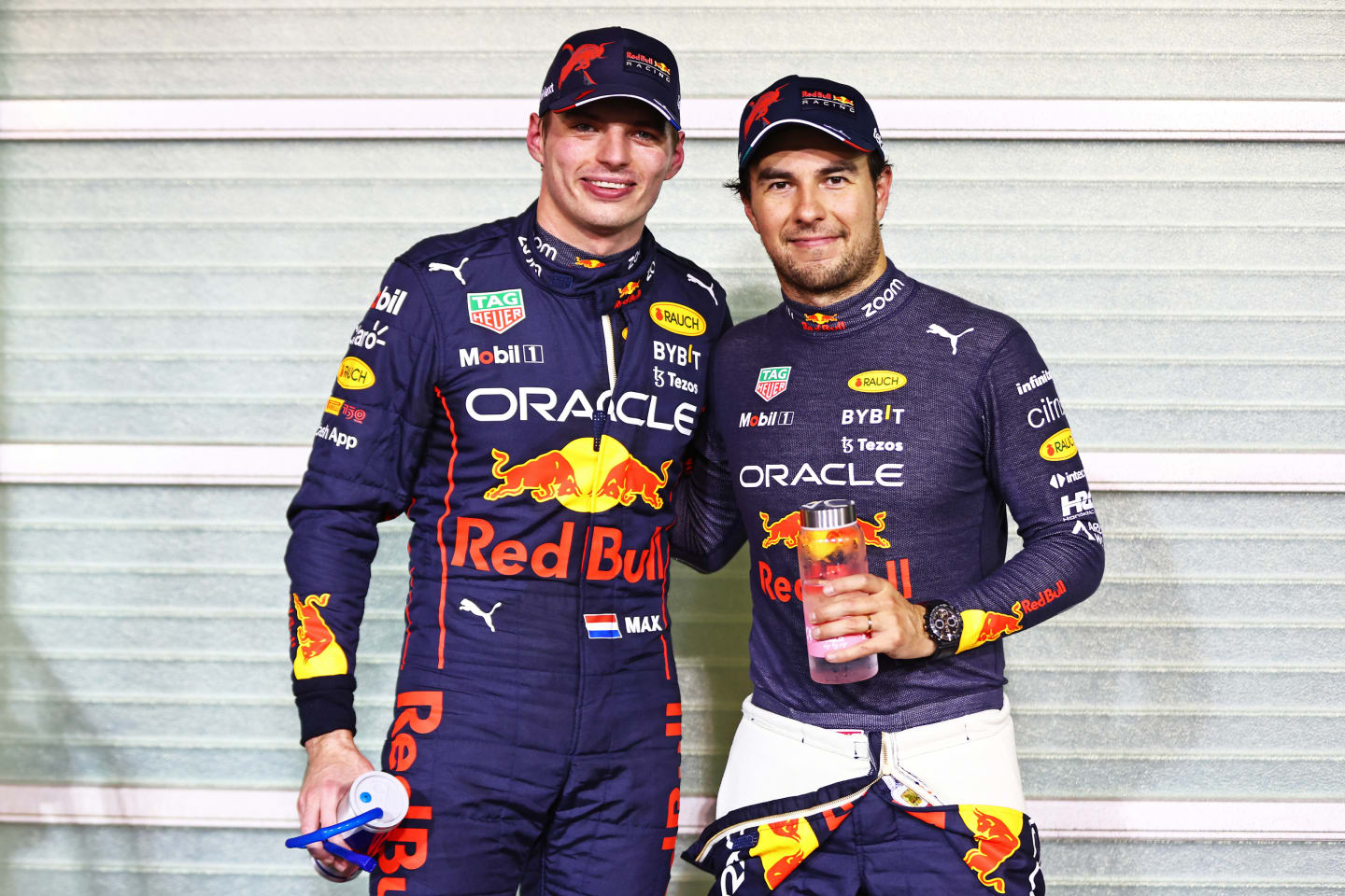 ABU DHABI, UNITED ARAB EMIRATES - NOVEMBER 19: Pole position qualifier Max Verstappen of the Netherlands and Oracle Red Bull Racing and Second placed qualifier Sergio Perez of Mexico and Oracle Red Bull Racing pose for a photo in parc ferme during qualifying ahead of the F1 Grand Prix of Abu Dhabi at Yas Marina Circuit on November 19, 2022 in Abu Dhabi, United Arab Emirates. (Photo by Mark Thompson/Getty Images)
