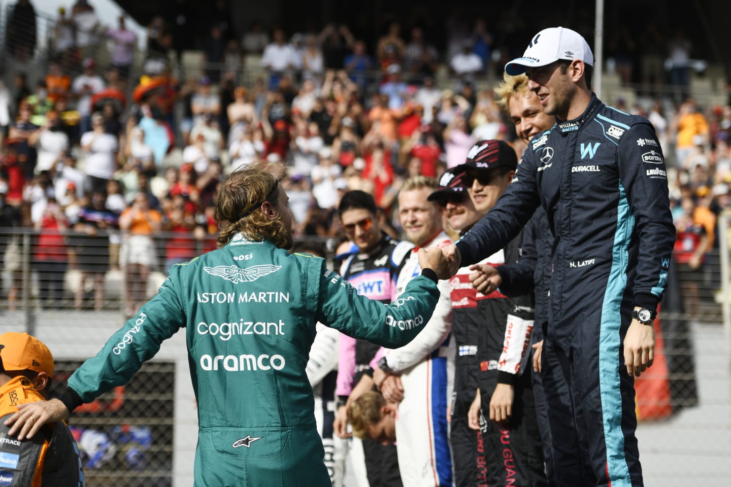 ABU DHABI, UNITED ARAB EMIRATES - NOVEMBER 20: Sebastian Vettel of Germany and Aston Martin F1 Team is greeted by Nicholas Latifi of Canada and Williams  as they prepare for the F1 2022 End of Year photo prior to the F1 Grand Prix of Abu Dhabi at Yas Marina Circuit on November 20, 2022 in Abu Dhabi, United Arab Emirates. (Photo by Rudy Carezzevoli/Getty Images)