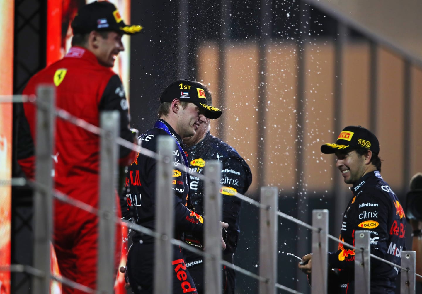 ABU DHABI, UNITED ARAB EMIRATES - NOVEMBER 20: Race winner Max Verstappen of the Netherlands and Oracle Red Bull Racing, Second placed Charles Leclerc of Monaco and Ferrari and Third placed Sergio Perez of Mexico and Oracle Red Bull Racing celebrate on the podium during the F1 Grand Prix of Abu Dhabi at Yas Marina Circuit on November 20, 2022 in Abu Dhabi, United Arab Emirates. (Photo by Joe Portlock - Formula 1/Formula 1 via Getty Images)