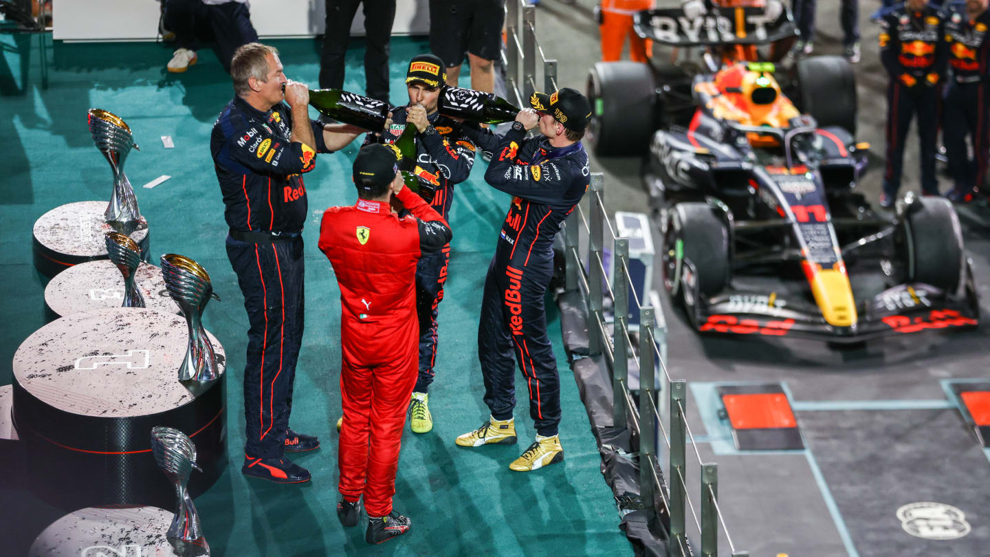 ABU DHABI, UNITED ARAB EMIRATES - NOVEMBER 20: Race winner Max Verstappen of the Netherlands and Oracle Red Bull Racing, second placed Charles Leclerc of Monaco and Ferrari, Olaf Janssen, Red Bull Racing Team Member and Third placed Sergio Perez of Mexico and Oracle Red Bull Racing celebrate on the podium during the F1 Grand Prix of Abu Dhabi at Yas Marina Circuit on November 20, 2022 in Abu Dhabi, United Arab Emirates. (Photo by Bryn Lennon - Formula 1/Formula 1 via Getty Images)