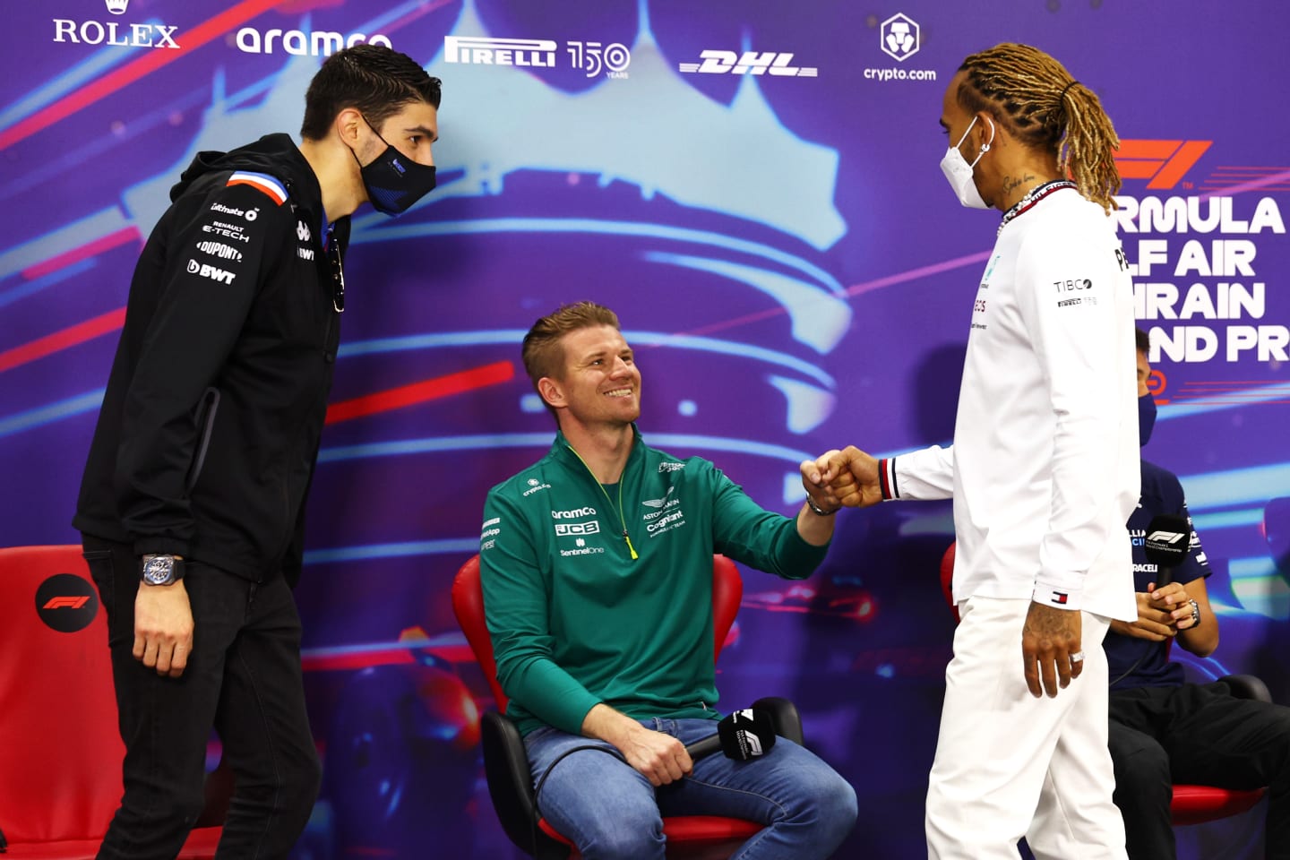 BAHRAIN, BAHRAIN - MARCH 18: Lewis Hamilton of Great Britain and Mercedes (R) and Esteban Ocon of France and Alpine F1 (L) greet Nico Hulkenberg of Germany and Aston Martin F1 Team (C) to the Drivers Press Conference before practice ahead of the F1 Grand Prix of Bahrain at Bahrain International Circuit on March 18, 2022 in Bahrain, Bahrain. (Photo by Lars Baron/Getty Images)