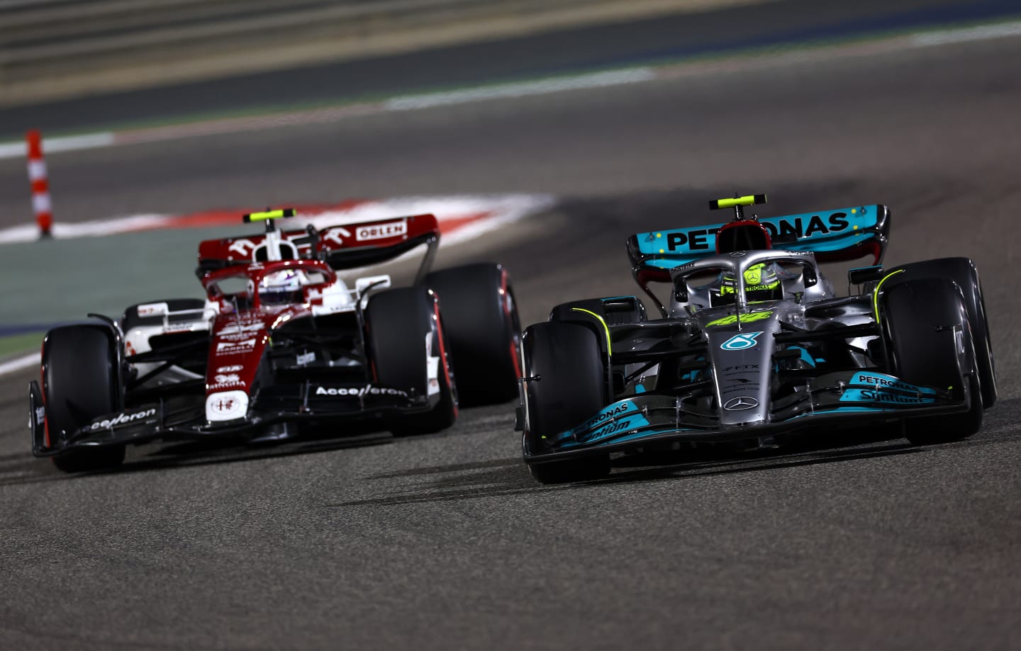 BAHRAIN, BAHRAIN - MARCH 20: Lewis Hamilton of Great Britain driving the (44) Mercedes AMG Petronas F1 Team W13 leads Zhou Guanyu of China driving the (24) Alfa Romeo F1 C42 Ferrari during the F1 Grand Prix of Bahrain at Bahrain International Circuit on March 20, 2022 in Bahrain, Bahrain. (Photo by Lars Baron/Getty Images)
