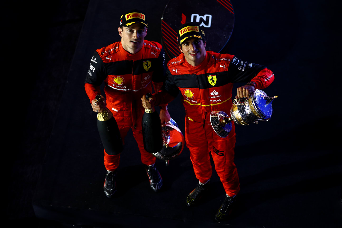 BAHRAIN, BAHRAIN - MARCH 20: Race winner Charles Leclerc of Monaco and Ferrari and Second placed Carlos Sainz of Spain and Ferrari celebrate on the podium during the F1 Grand Prix of Bahrain at Bahrain International Circuit on March 20, 2022 in Bahrain, Bahrain. (Photo by Mark Thompson/Getty Images)